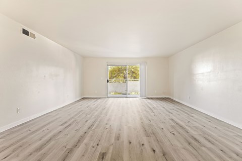 A room with wooden flooring and a window.