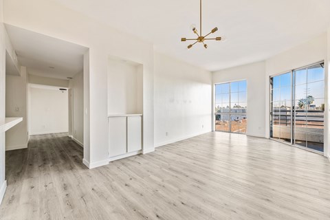 A large, empty room with wooden floors and white walls.