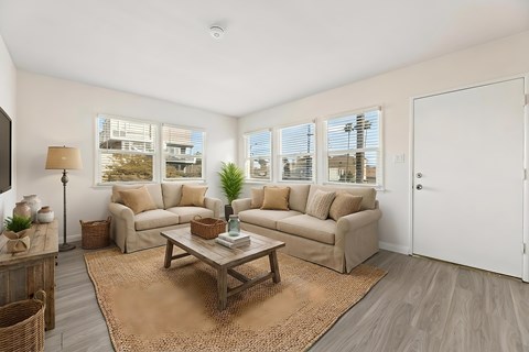 A living room with a brown rug and a wooden coffee table.