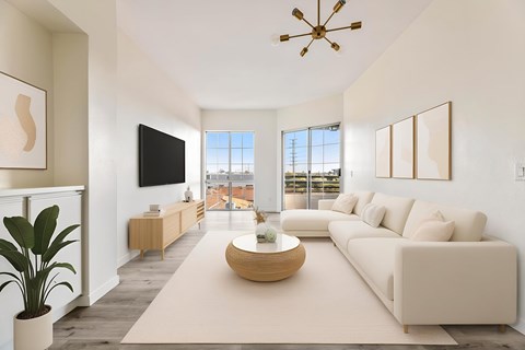 A modern living room with a large sofa, a coffee table, and a flat-screen TV.