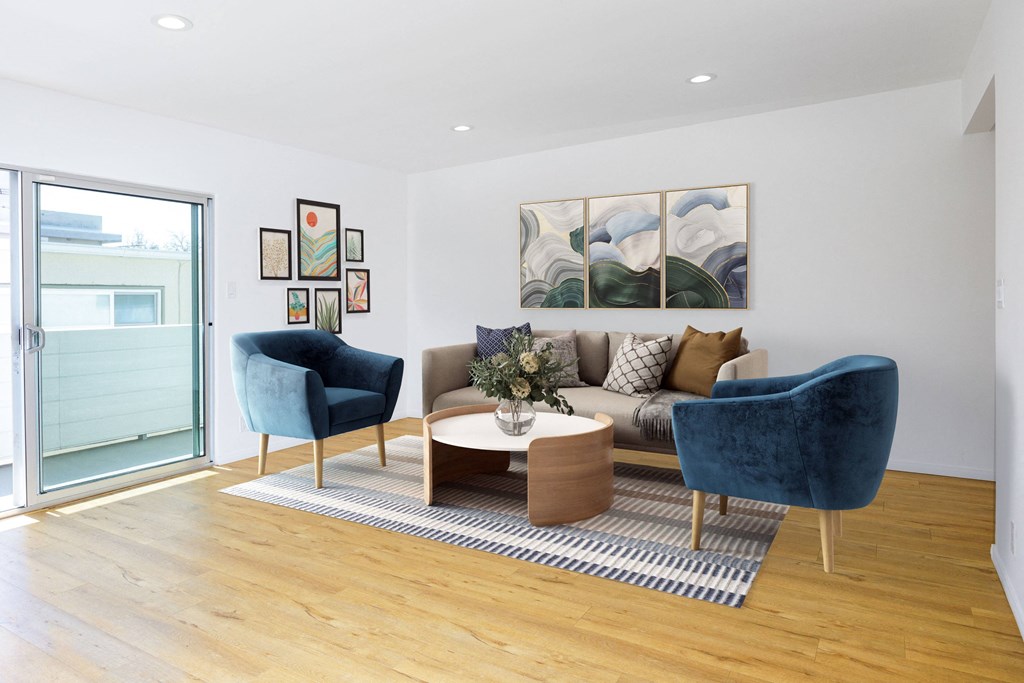 a living room with a couch and two chairs and a rug