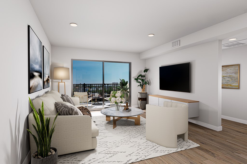 A modern living room with a large window, a couch, a coffee table, and a flat-screen TV.