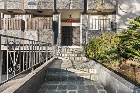 A building with a black door and a metal railing.