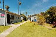 a row of houses in a yard with a sidewalk