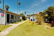 a row of houses in a yard with a sidewalk