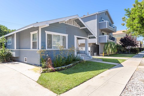 a blue house with a sidewalk in front of it