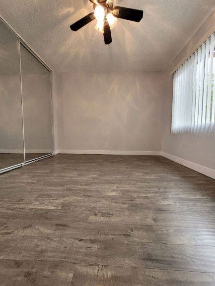an empty living room with a ceiling fan