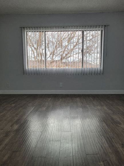 an empty room with wood floors and a window
