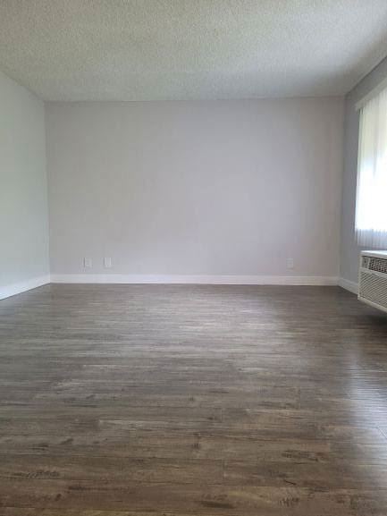 an empty living room with wooden floors and a window