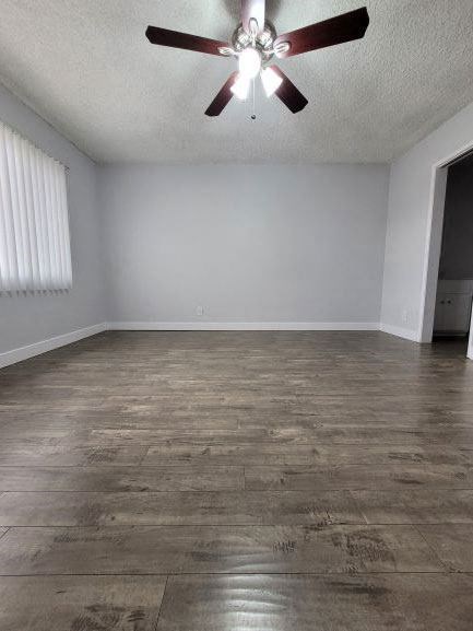 an empty living room with a ceiling fan