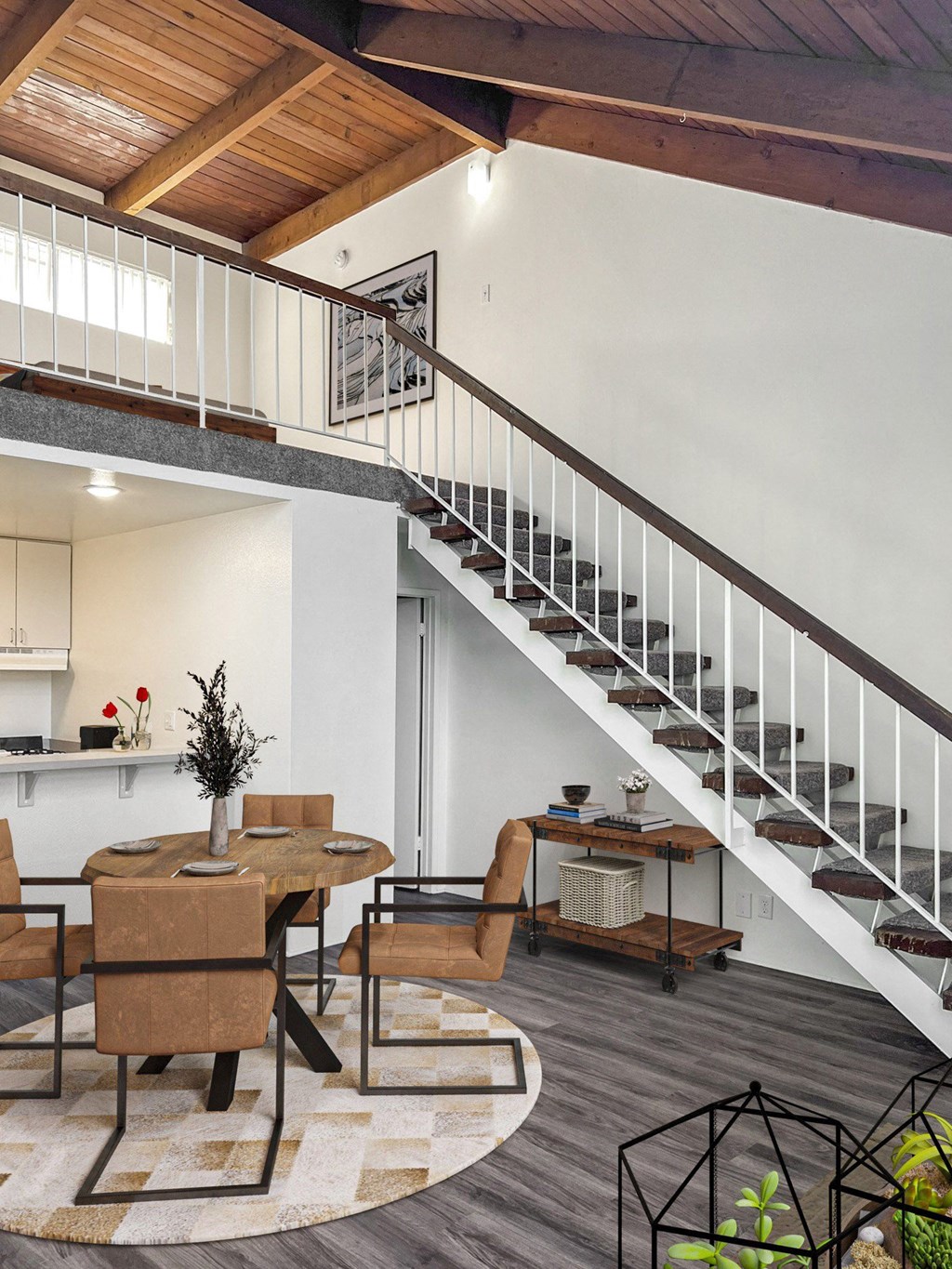 a living room with a staircase and a table and chairs