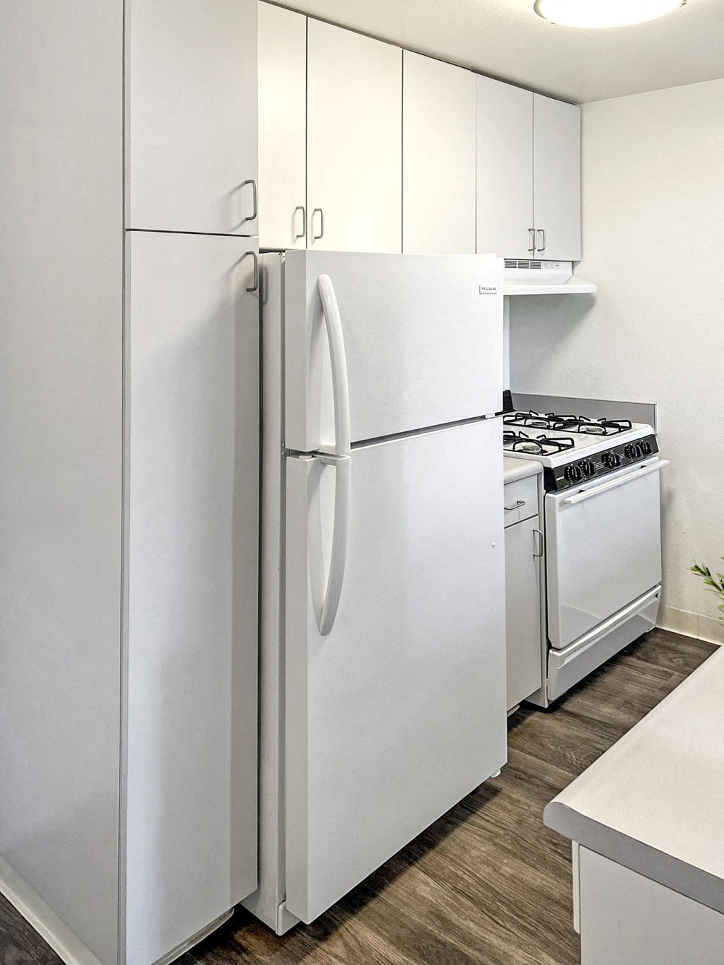 a kitchen with white appliances and a white refrigerator