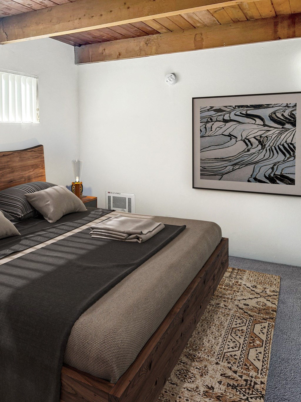 a bedroom with a bed and a painting on the wall