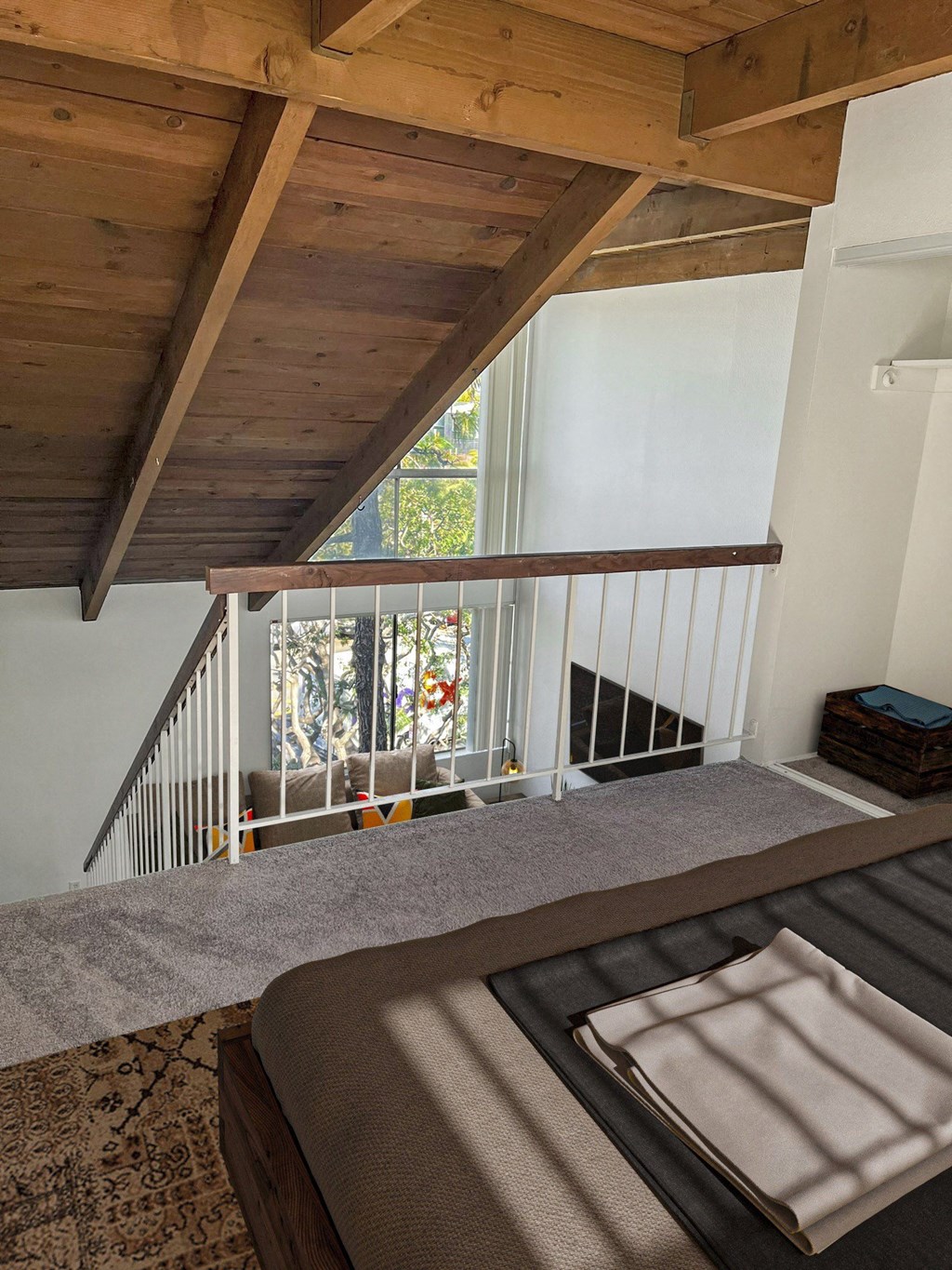 a bedroom with a bed and a staircase with a window