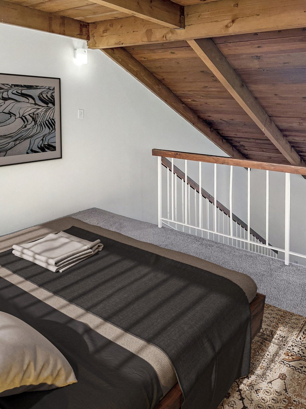 a bedroom with a bed and a staircase in a loft