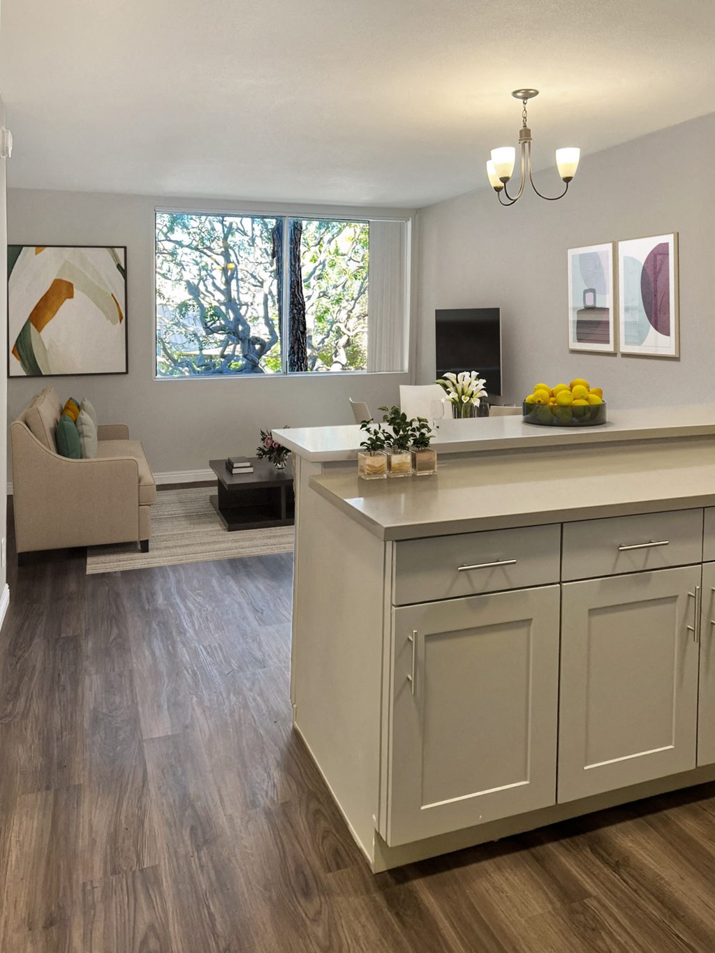 a kitchen with an island and a living room with a couch and a tv