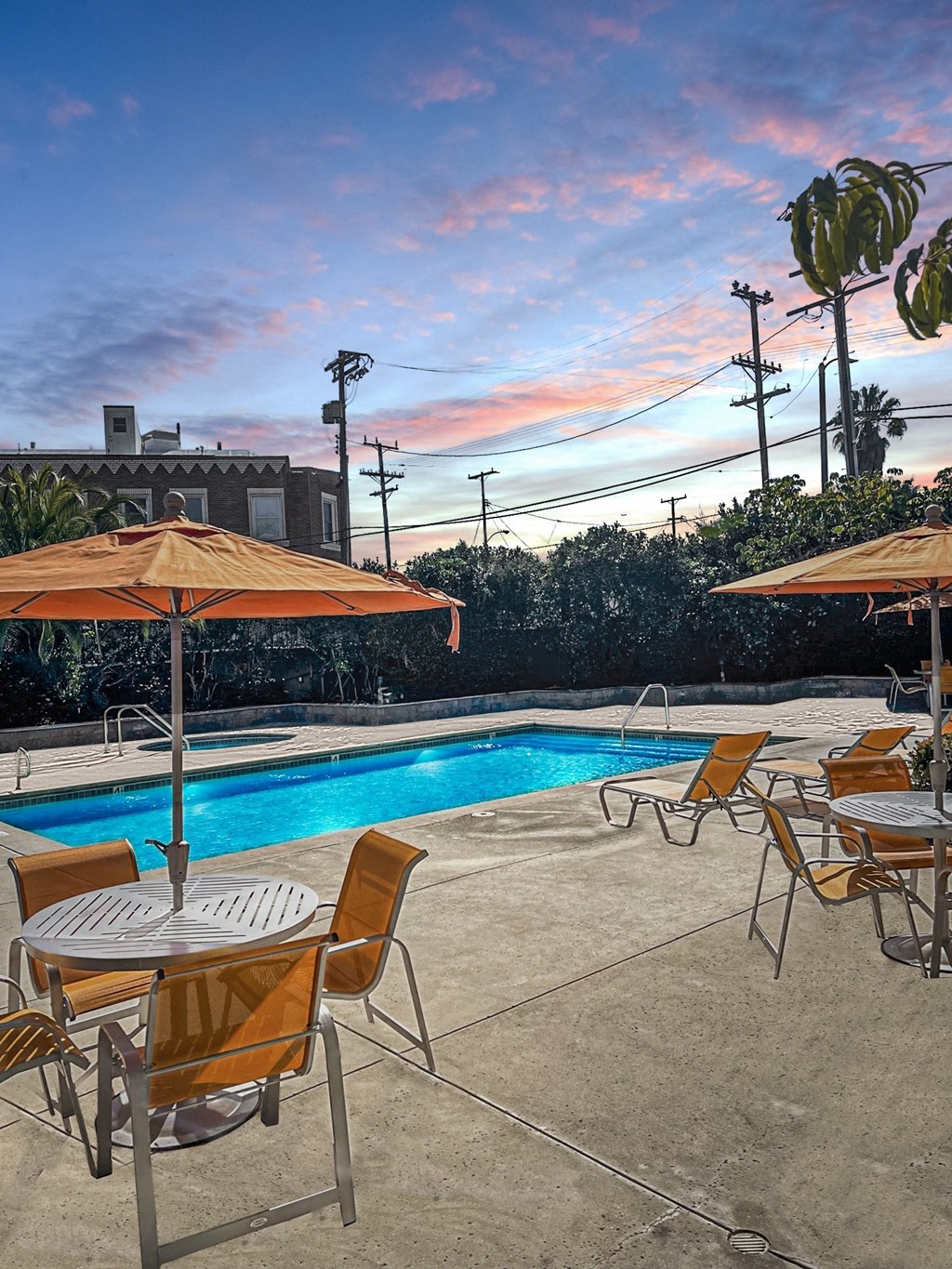 a swimming pool with tables and umbrellas next to it