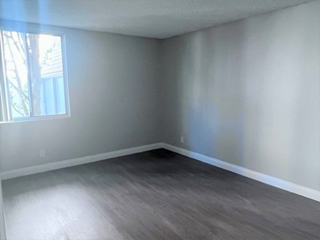 an empty room with white walls and a window