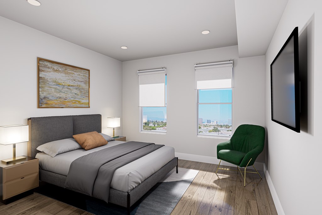 A bedroom with a large bed and a green chair.