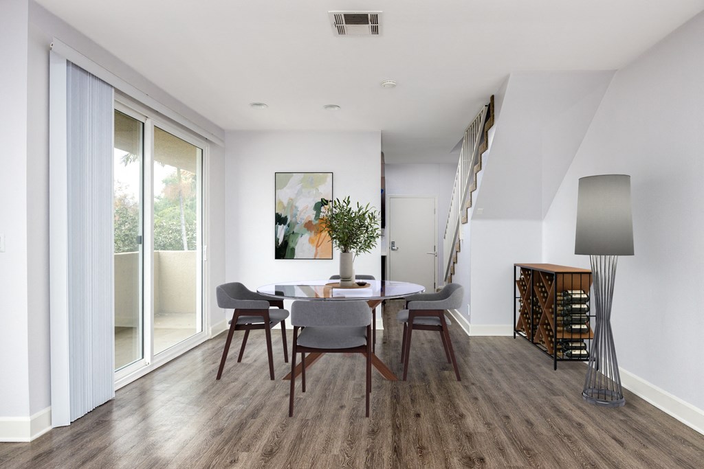 a dining room with a table and chairs and sliding glass doors