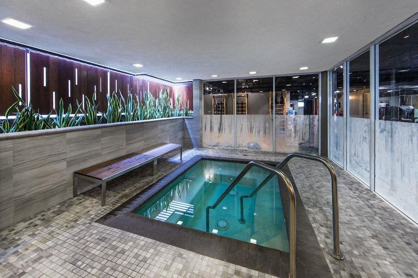 a small pool in the middle of a room with a bench