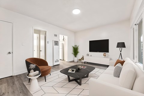 A modern living room with a white couch, a brown chair, and a black coffee table.