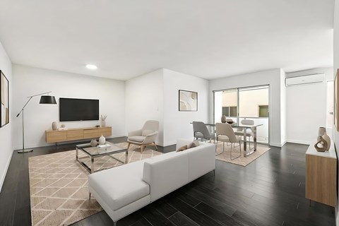A modern living room with a white sofa and a glass coffee table.