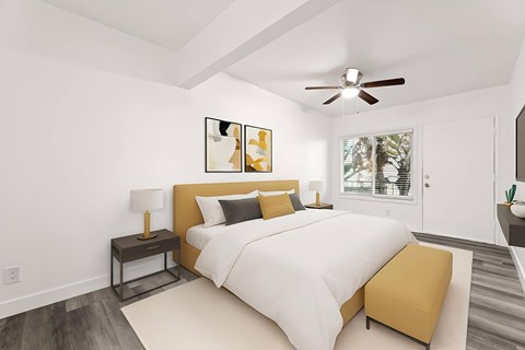 A bedroom with a large bed and a ceiling fan.