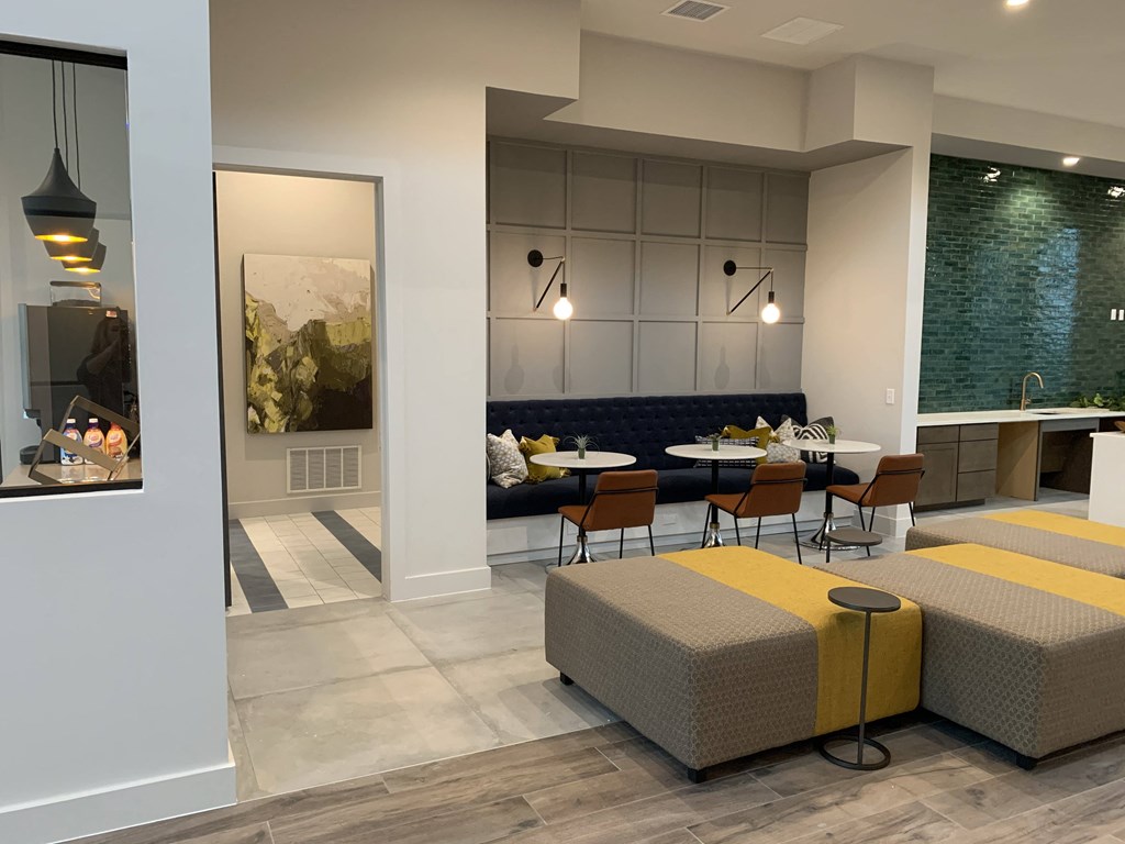 a rendering of a lobby with tables and chairs and a fireplace