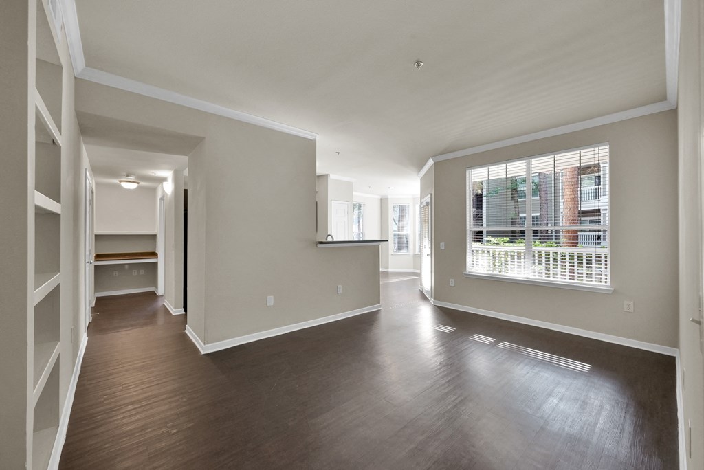 a bedroom with hardwood flooring and a large window