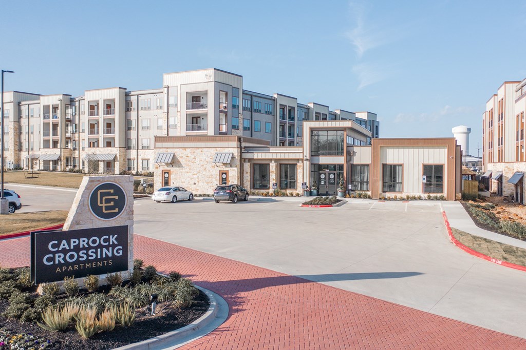 a building with a parking lot and a sign that reads carpet crossing apartments