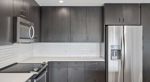 A modern kitchen with a stainless steel refrigerator and microwave.