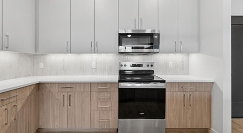A modern kitchen with a black oven and wooden cabinets.