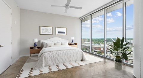 A bedroom with a large bed and a view of the city.