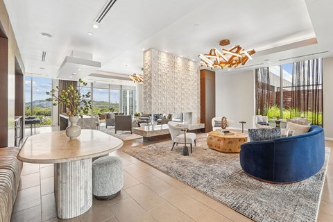 A modern living room with a large round table and a blue sofa.