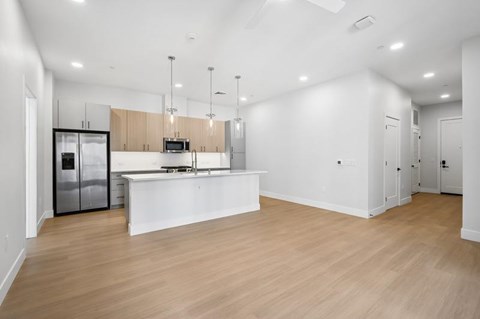 A kitchen with a white counter and wooden floors.