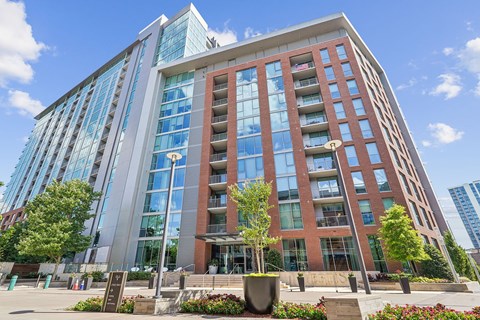 A modern multi-story building with a glass facade and a red brick exterior.