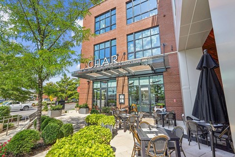 A patio area of a building with tables and chairs.