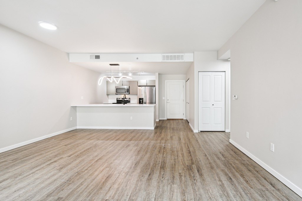 A room with a kitchenette and a doorway leading to another room.