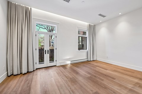 A room with a white wall and a wooden floor.