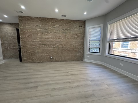A room with a brick wall and wooden flooring.