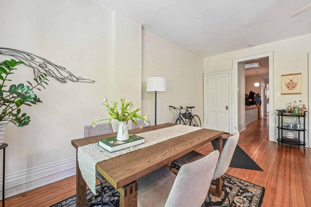 a dining room with a wooden table and chairs     and a hallway