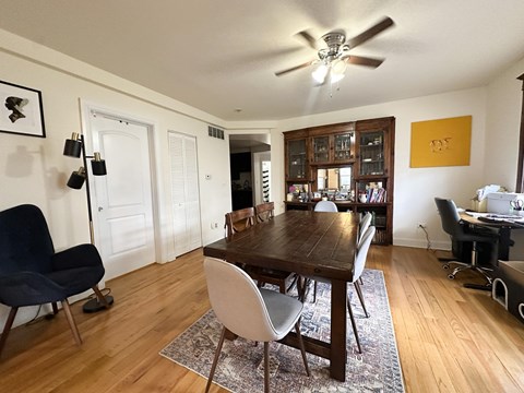 A dining room with a wooden table and chairs.