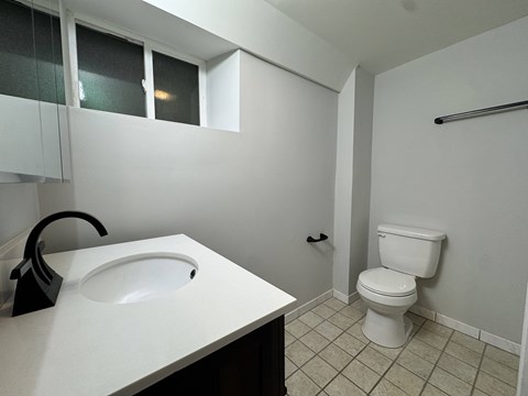 A white sink in a small bathroom with a toilet.