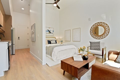 A bedroom with a bed, a chair, and a table.