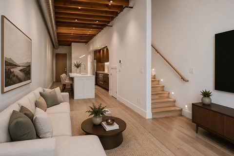 A living room with a white couch and a brown coffee table.