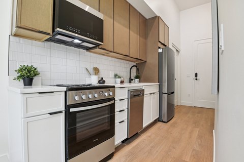 A kitchen with white cabinets and a black microwave.