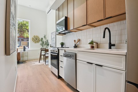 A kitchen with white appliances and wooden cabinets.