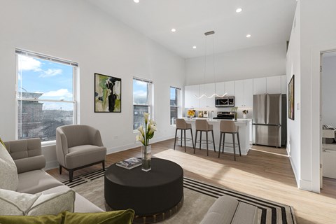 a living room with a couch and a table in front of a kitchen
