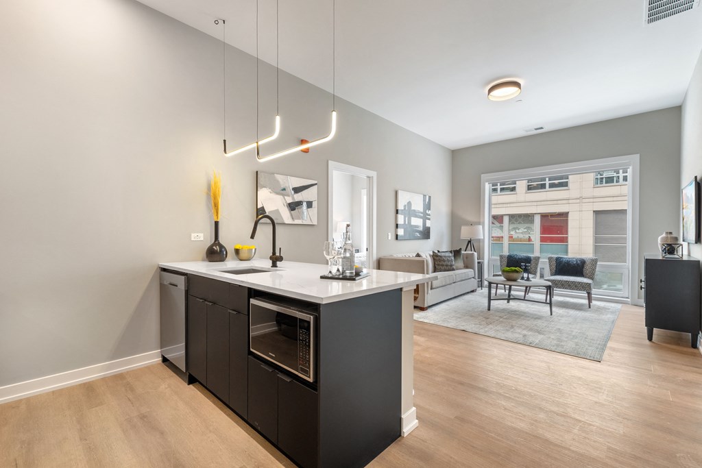 an open living room and kitchen area with a large window and a kitchen island